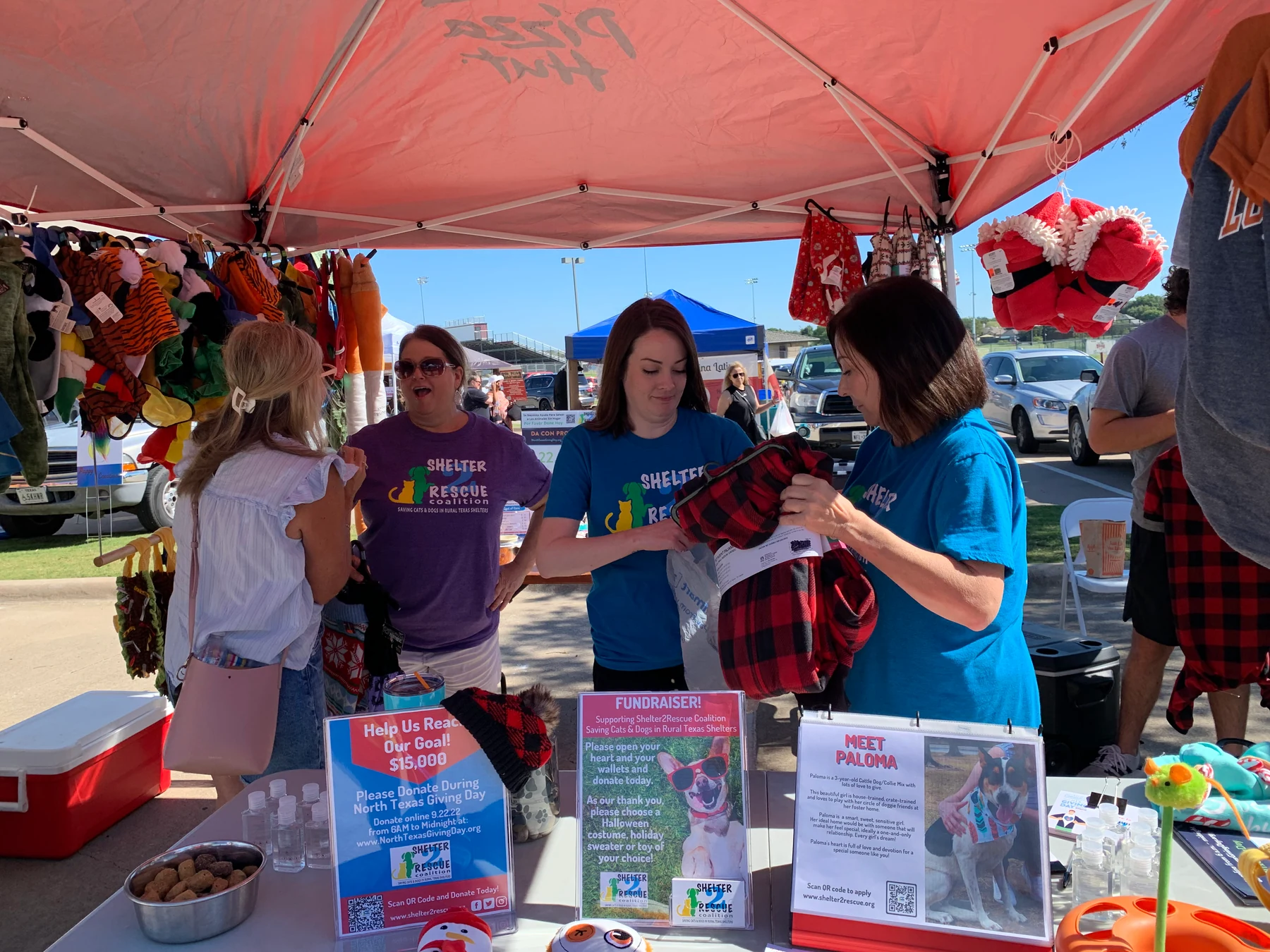 Shelter2Rescue volunteers speaking with a visitor at a community event
